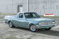 an old blue car parked in front of a building with the words street machine on it