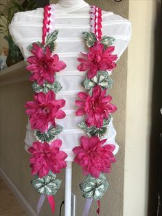 a mannequin with pink flowers and dollar bills on it's neckline