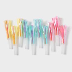 six toothbrushes lined up in a row on a white surface with different colors