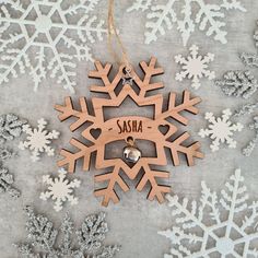 wooden snowflake ornament with personalized name and bell hanging from string