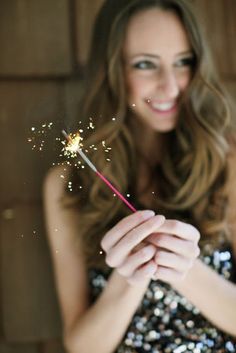 a woman holding a sparkler in her hands