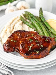 grilled pork chops, mashed potatoes and asparagus on a white plate