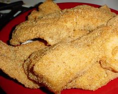 fried chicken sticks on a red plate with tongs