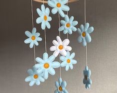 a blue and white flower mobile hanging from a ceiling