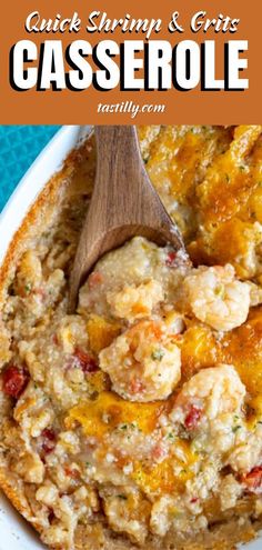 a casserole with shrimp and cheese in it on a white plate next to a wooden spoon