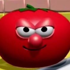 a red tomato with eyes and nose sitting on a counter