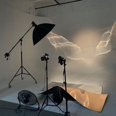 an empty studio with lighting equipment in front of it and on the floor behind them