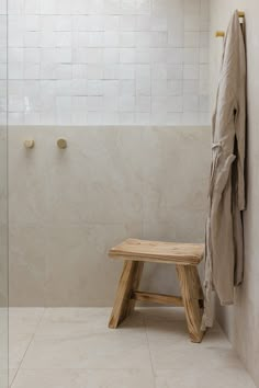 a wooden bench sitting next to a shower