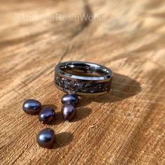 two rings with pearls are sitting on a wooden table