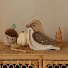 a wooden shelf topped with figurines next to a basket filled with pumpkins