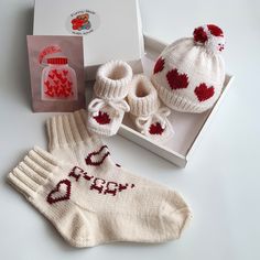 a pair of knitted baby booties and socks in a box next to a package