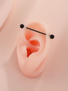 an ear with two black pins sticking out of it