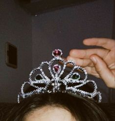 a close up of a person holding a tiara