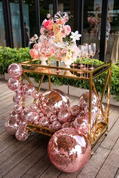 a table topped with lots of shiny pink balloons