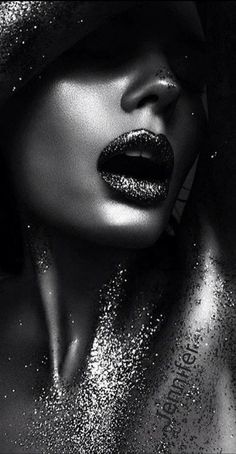 a black and white photo of a woman's face with glitter on her lips