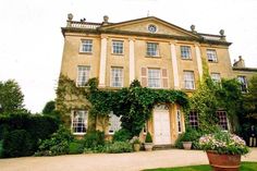 a large building with many windows and plants in the front yard