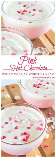 pink hot chocolate with marshmallow whipped cream in a glass dish on a wooden table