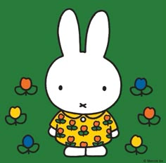 a white rabbit wearing a yellow shirt with flowers on it's chest, standing in front of green background