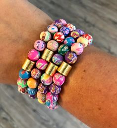 a woman's arm with colorful bracelets on it