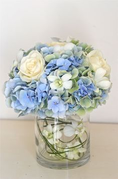 a glass vase filled with blue and white flowers