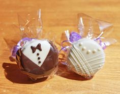 two chocolate covered candies in cellophane wrappers with bow ties on them