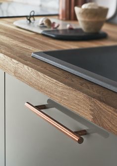 a wooden counter top with a metal handle on it