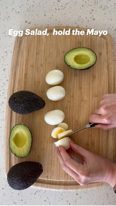 an avocado cut in half on a cutting board with the words egg salad hold the mayo