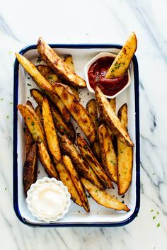 french fries with ketchup and mayonnaise on the side in a tray