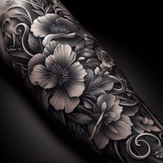 a black and white tattoo with flowers on the arm, done by an artist in his studio