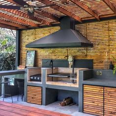 an outdoor kitchen is built into the side of a wooden structure with grill and counter space