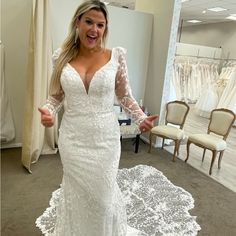 a woman in a white wedding dress posing for the camera with her arms outstretched and hands out