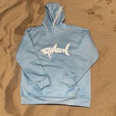 Brand New, Never Worn Light Blue, Cozy Hoodie With “Shark” Written On The Front Backside Is Solid Blue Size Medium Measures 22 Inches From Armpit Seam To Armpit Seam And 17 Inches From Armpit Seam To Bottom Hem Blue Hoodie Men, Light Blue Hoodie, Shark Hoodie, Cozy Hoodie, Walker Boots, Garment Bags, Rain And Snow Boots, Swim Trunks, Jean Coat