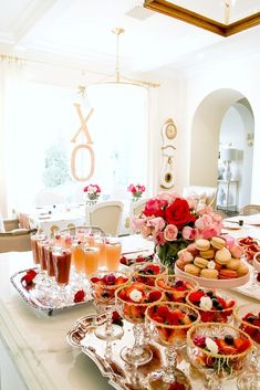 a table filled with desserts and drinks on top of a white countertop next to a window