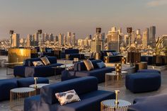 an outdoor seating area with blue couches and cityscape in the back ground