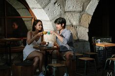 a man and woman sitting at a table eating cake