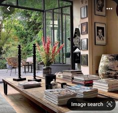 a living room filled with lots of furniture and books on top of a wooden table