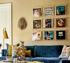 a living room filled with blue couches and pictures on the wall above them,