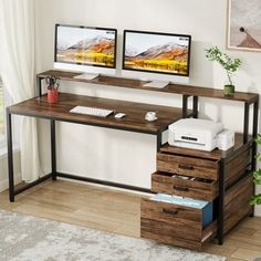 two computer monitors sitting on top of a wooden desk in front of a white wall