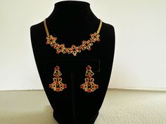 "Vintage red rhinestone necklace and earring set by Garne.  This Art Nouveau/Edwardian style matching set is a high quality example of collectible costume jewelry.  From the 50s, the necklace/choker measures approximately 15 1/2\".  The earrings are approx. 1 1/4\" in length and are screw back.  It has all it's rhinestones, which are a rich ruby/cranberry red, and are prong set.  Made of a smooth, shiney gold tone metal, which has never tarnished.  It is unmarked, but has the hallmark of Garne.  In excellent vintage condition.  I do not have the original box.  A fun and elegant Christmas or Holiday jewelry set, or unique Christmas gift for a friend.  Thanks for looking! FREE SHIPPING in US INTERNATIONAL SHIPPING - if shipping costs are less than estimated, the difference is refunded." Elegant Red Jewelry Sets For Festive Occasions, Festive Red Necklaces With Matching Earrings, Festive Red Necklace With Matching Earrings, Red Costume Jewelry Sets For Formal Occasions, Red Jeweled Jewelry Sets For Party, Red Jeweled Jewelry For Evening, Formal Red Jeweled Jewelry Sets, Red Evening Jewelry, Red Temple Jewelry Necklaces For Formal Occasions