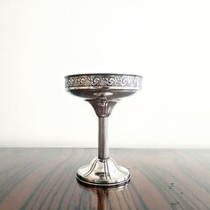 a silver bowl sitting on top of a wooden table