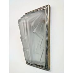 a mirror hanging on the wall with an artistic design in it's center piece