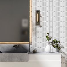 a bathroom with a sink, mirror and plant on the counter top in front of it