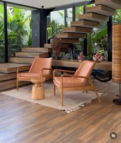 a living room filled with lots of furniture next to a stair case in front of a window