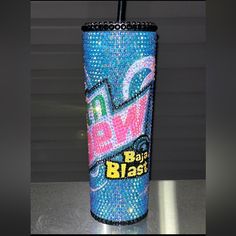 a blue and pink bling bling cup with a straw in it