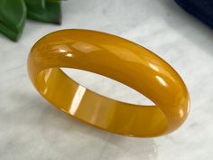 "A vintage chunky Bakelite bangle bracelet in butterscotch yellow. Tested with Simichrome. No marks. Measures about .75\" wide and 8.25\" around on the inside. Some scratches. Actual packaging will vary depending on item/s purchased and tape pattern available. Props/boxes shown in photos are for display purposes only, not included in this listing. As always, satisfaction is guaranteed. Thanks for shopping Vintage In Bloom More Bakelite: http://www.etsy.com/shop/VintageInBloom/search?search_query Vintage Yellow Round Bracelets, Retro Yellow Bangle Bracelets, Retro Yellow Bangle Bracelet, Handmade Vintage Yellow Bracelets, Prop Box, Tape Pattern, Bakelite Jewelry, Bakelite Bangles, In Bloom