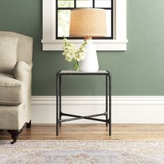 a living room scene with focus on the end table and chair next to the window