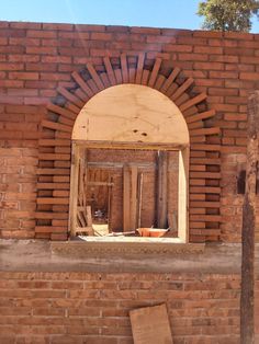 a brick wall with an arched window in the middle