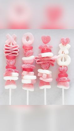 pink and white lollipops are arranged on sticks