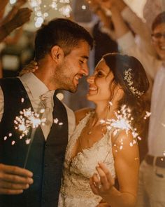 a bride and groom are surrounded by sparklers