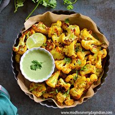 a bowl filled with roasted cauliflower and garnished with cilantro